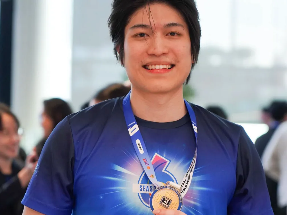 Ohm smiles and holds the Super AI Engineer Season 6 gold medal.
